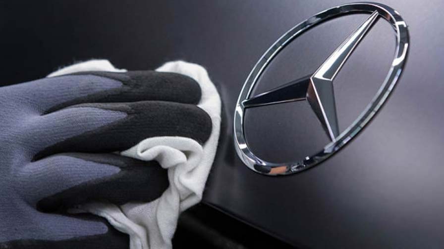 Mecanico de chaperia y pintura limpiando la estrella de Mercedes-Benz